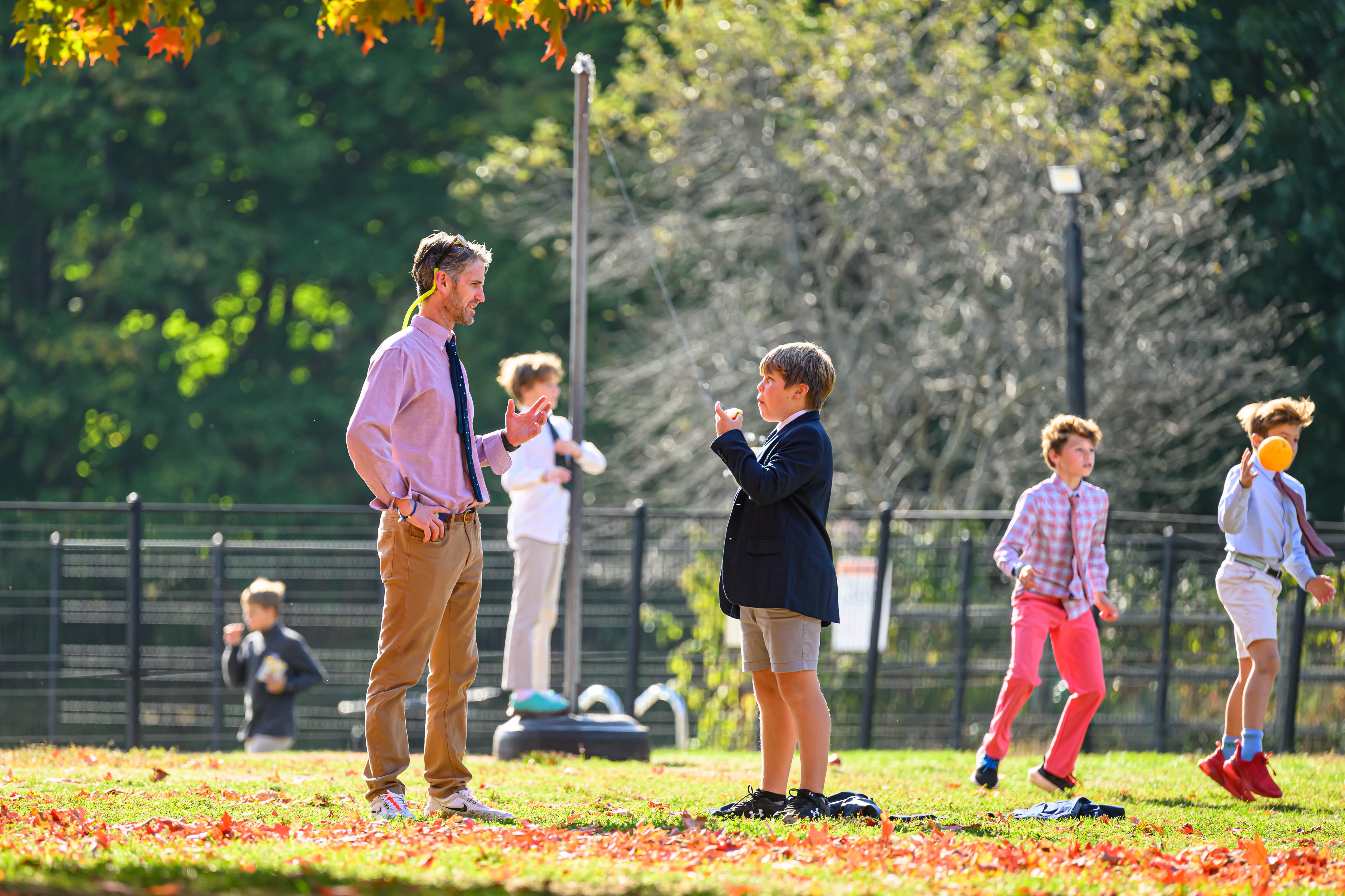 Fessenden student learning from a teacher on the playground
