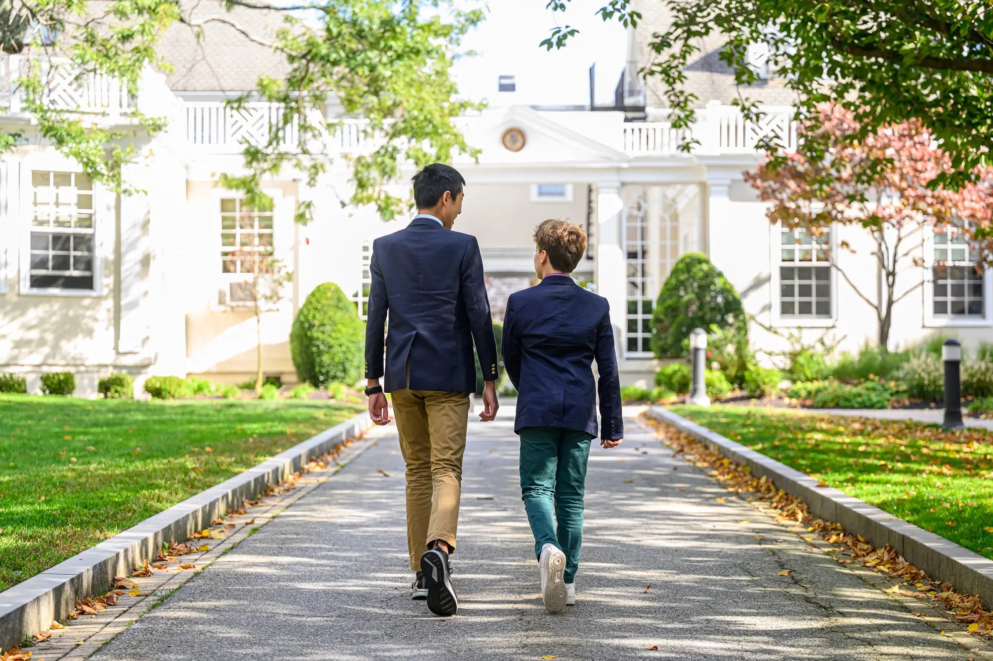 A young boy and teen boy walk away from the camera