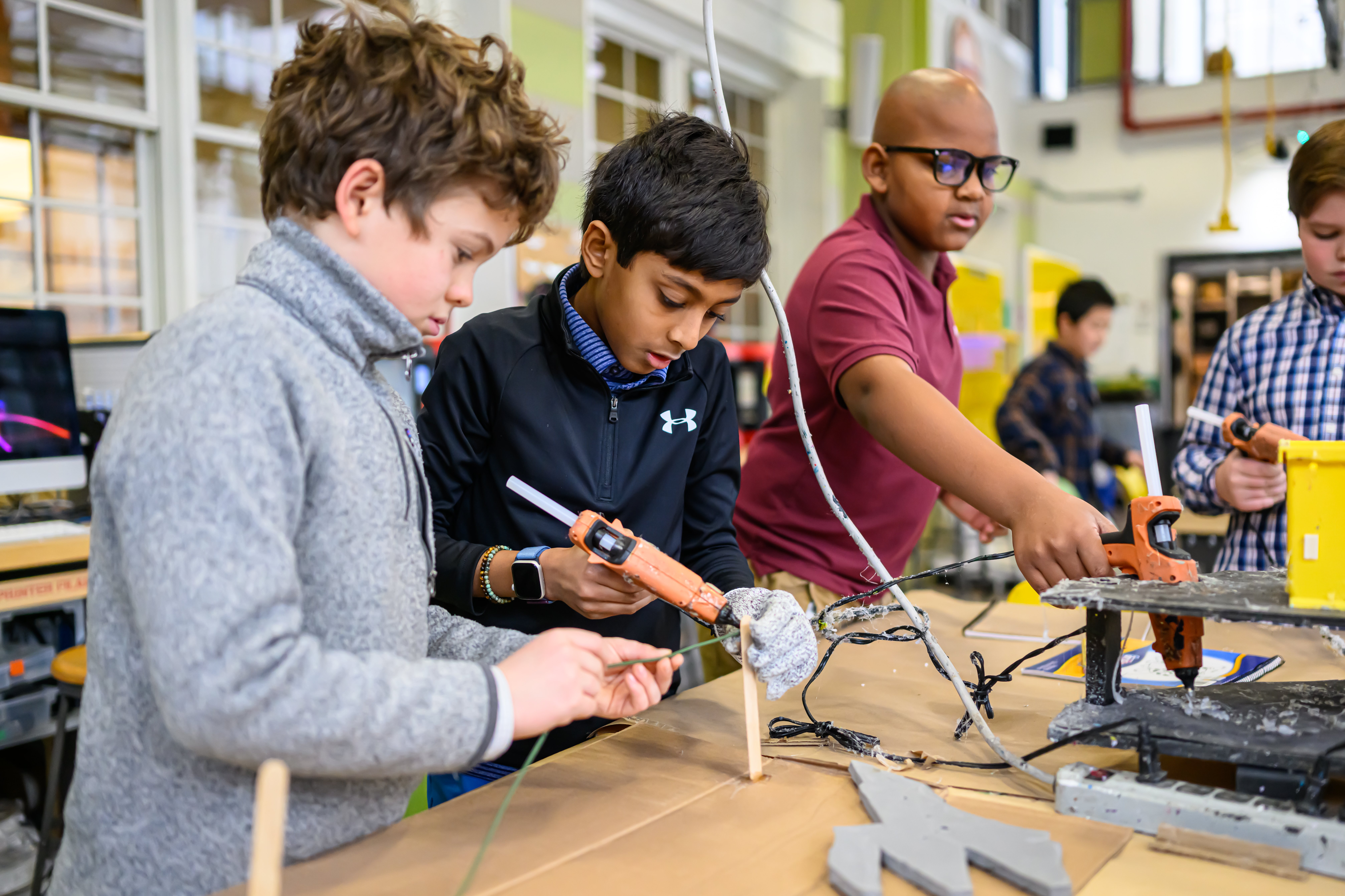 Four elementary school students at Fessenden working together during workshop class
