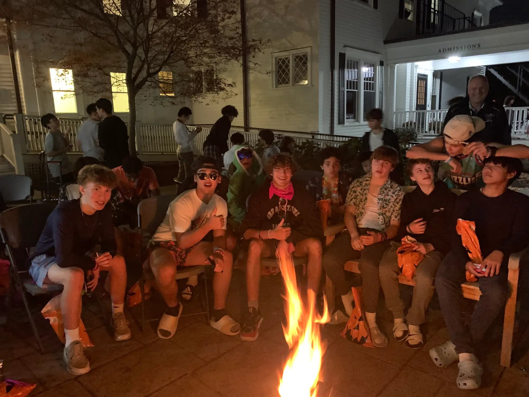 boys gather around a fire