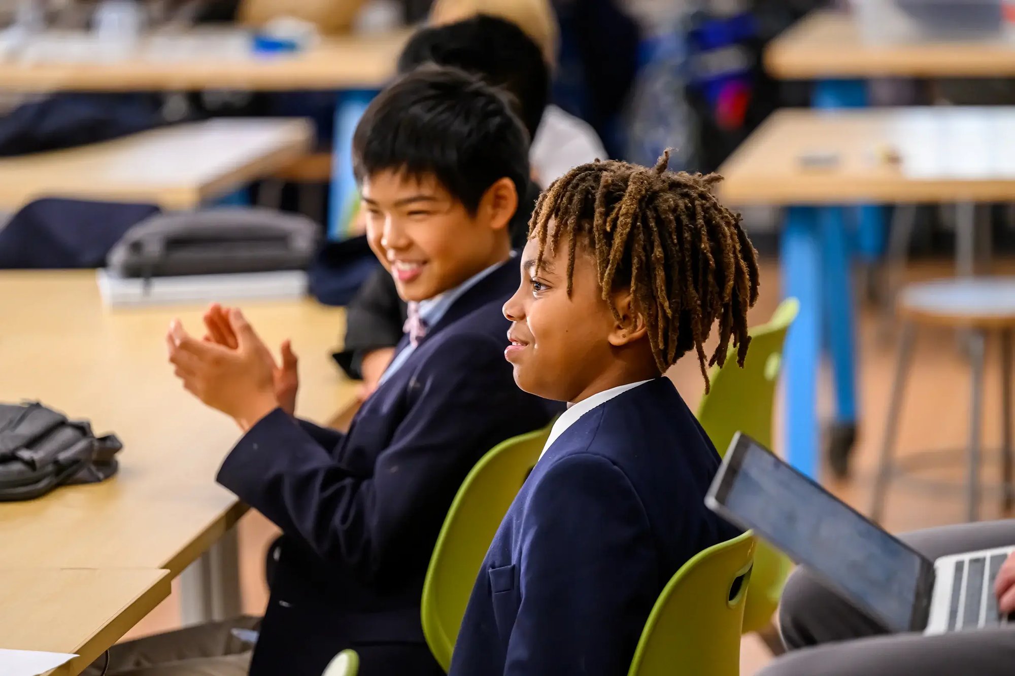 Boys sittings at desks smiling