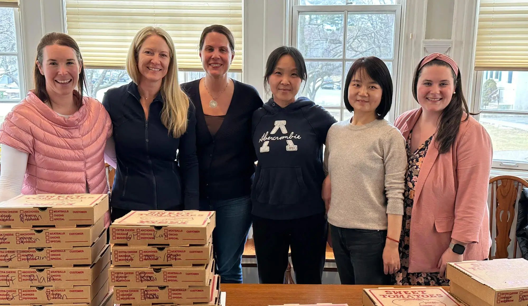 Faculty staff appreciation - women standing behind pizza boxes