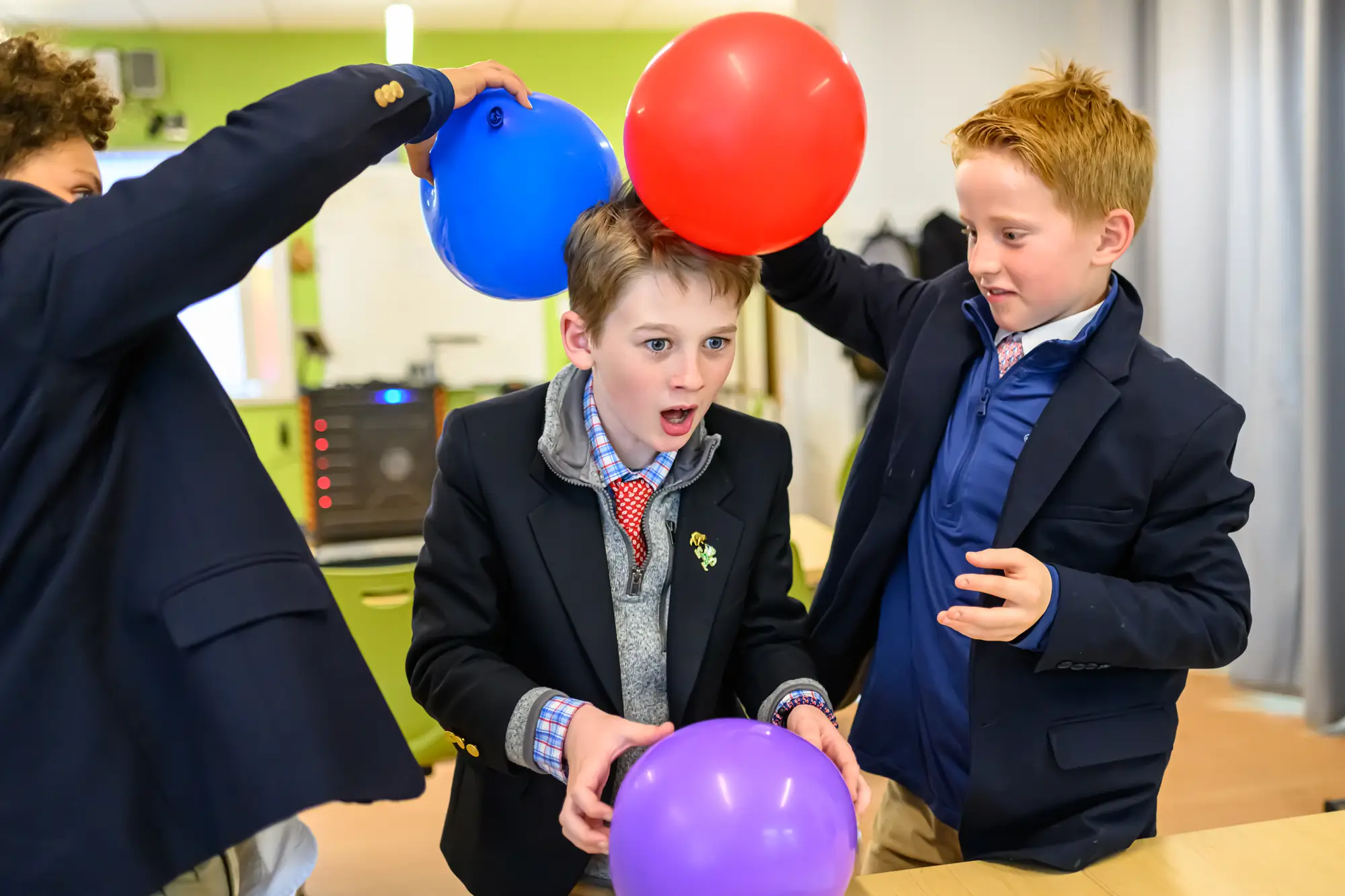 three boys use baloons to create static