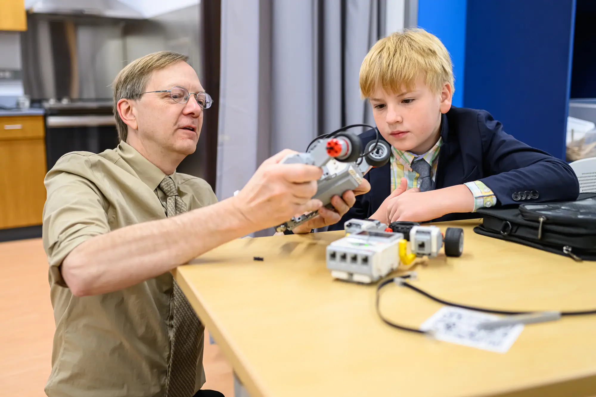 Science Bob helps Middle School student with robotics projecta male teacher helps a student with a science project